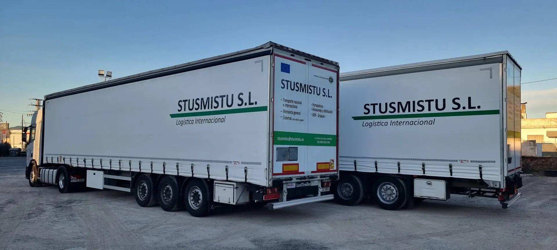 Dos camiones de lona de STUSMISTU con el logotipo de la empresa